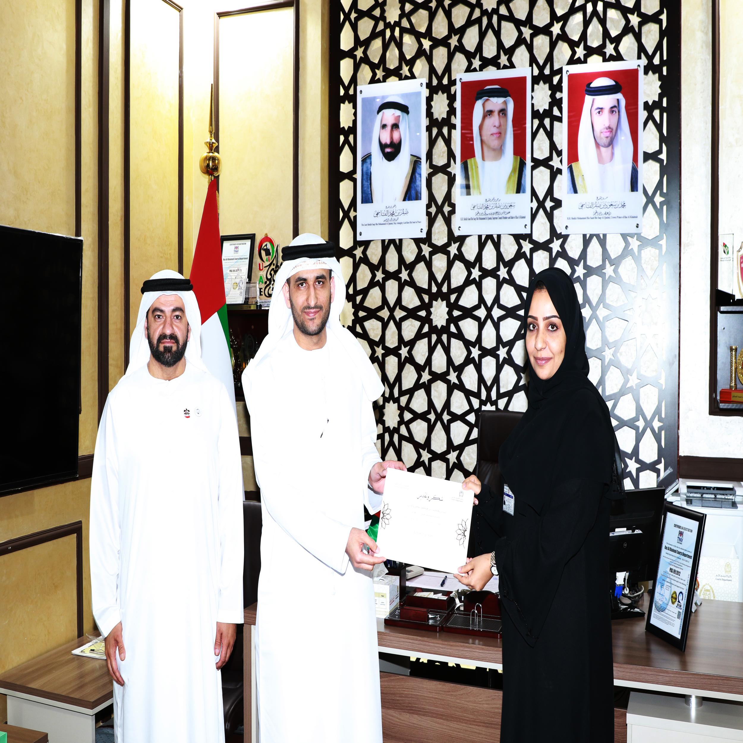 مدير عام محاكم رأس الخيمة، يكرم موظفة لتميزها في تقديم الخدمات للمتعاملين